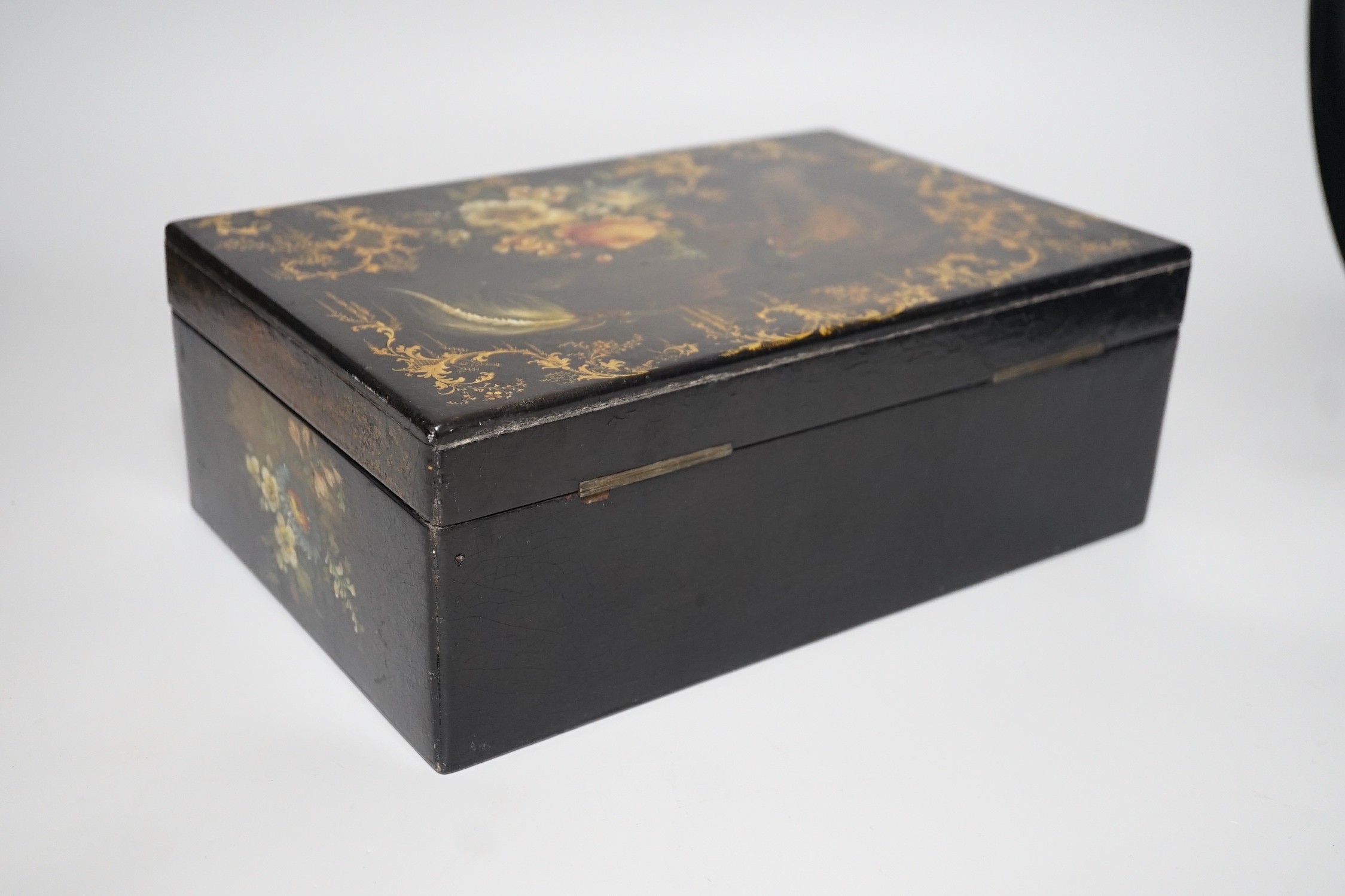 A Victorian painted papier-mâché sewing box, with peacock, blossom and gilt decoration with wooden inset, 30cms wide x 11cms high